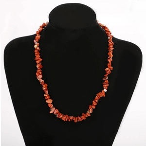 Macro view of multi-layered natural red stone necklace on a black velvet display stand