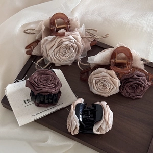 Detailed view of dried rose hair claws in beige and brown with elegant fabric texture