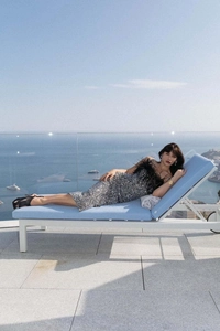 Elegante abito in paillettes d'argento con piume nere su sedia da spiaggia