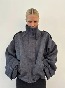 Detail of dark grey wool blend coat featuring high collar and stylish shoulder epaulettes