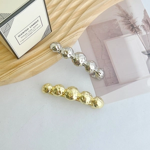 Polished geometric star spring hair clips in gold and silver with bubble texture