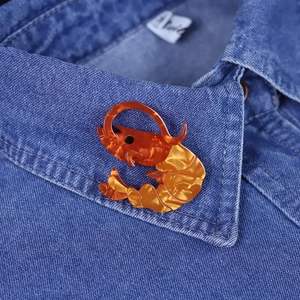 Fashionable acrylic lobster brooch in orange and yellow on a blue denim jacket collar