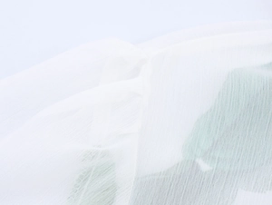 Détail du tissu en mousseline blanche montrant la texture légère et semi-transparente