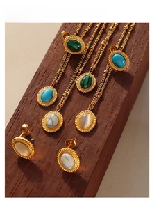 French Bohemian gold jewelry set featuring turquoise and malachite stones on wood