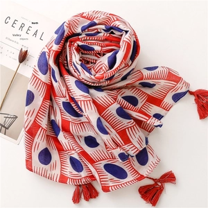 Detail shot of lightweight cotton-linen scarf with red blue patterns and tassel edges