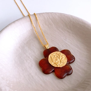 Macro view of flower resin pendant with vintage amber tortoiseshell pattern and gold crest