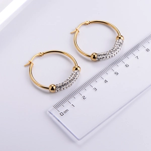 Detail shot of 3cm gold zircon hoop earrings next to a ruler for precise size measurement