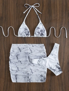 Detailed flat lay of a marble print 3-piece bikini set with a drawstring mini skirt