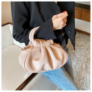Detailed view of pink pleated handbag with soft PU leather texture and sturdy top handle