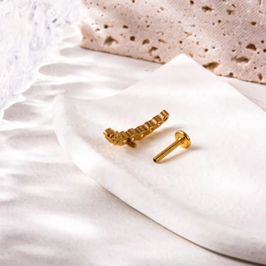 Detailed view of gold titanium labret stud with zircon crown and threaded flat back base