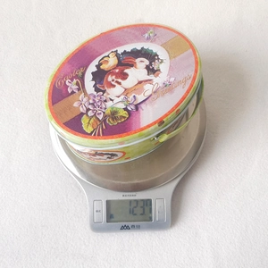Macro view of Easter tin gift box on a digital scale showing its weight and handle
