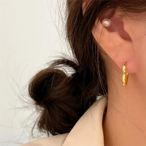 Elegant 925 sterling silver gold heart hoop earrings on female model in a profile view
