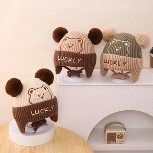 Detail of winter knit bear hats with double pom-poms and ear protection for kids