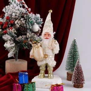 Close-up of a plush Santa Claus doll in white and gold with a sack and mini tree