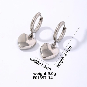 Détail de boucles d'oreilles cœur argentées avec dimensions 1,3 cm de large et 2,9 cm