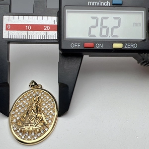 Calibre digital midiendo los 26,2 mm de largo del colgante dorado de la Virgen María