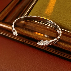 Gros plan d'un bracelet ouvert argenté texturé avec des pierres de zircon serties