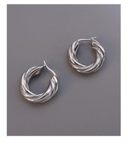 Close-up of silver twisted rope hoop earrings with polished texture and secure latch back