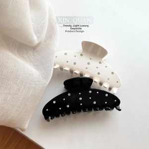 Detail of elegant black and white hair claws with sparkling rhinestones in a sleek finish