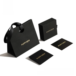 Detail of luxury matte black gift bag and drawer jewelry box with gold foil branding