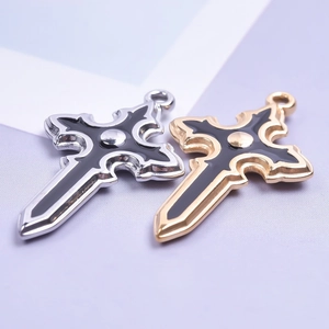 Macro shot of silver and gold stainless steel cross pendants with black enamel filling
