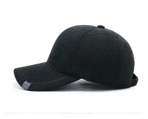 Close-up of grey herringbone wool texture and metal accent on winter baseball cap
