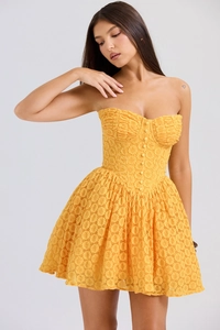Detailed macro shot of yellow lace corset dress with 3D floral texture and buttons
