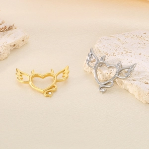 Detailed view of heart-shaped angel and devil wing pendants with crystal accents