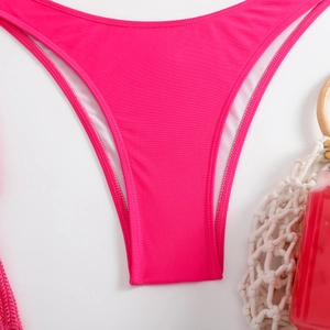 Detailed close-up of rose red ribbed bikini bottom with neat stitching and mesh lining
