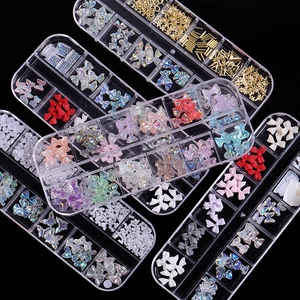Aurora crystal butterfly resin nail charms set in clear storage boxes on black background