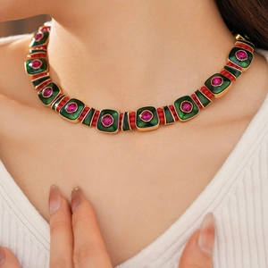 Detail of vintage choker necklace with green enamel squares and pink gemstone inlay