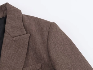 Détail d'un blazer marron en tissu tissé avec texture et coutures sur le revers