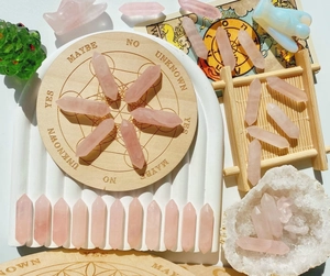 Macro shot of polished rose quartz hexagonal pillars on a wooden divination board