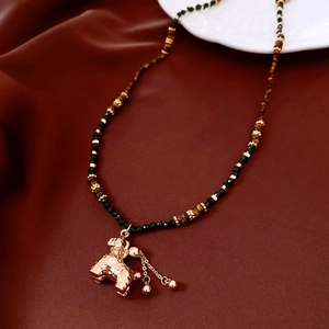 Détail du collier de perles avec pendentif caniche doré et pierres œil de tigre