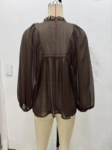 Detail of coffee brown chiffon blouse showing ruffled collar and sheer puff sleeves