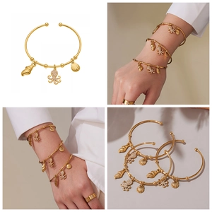 Golden ocean charm bracelet with octopus and shell pendants featuring white zircons