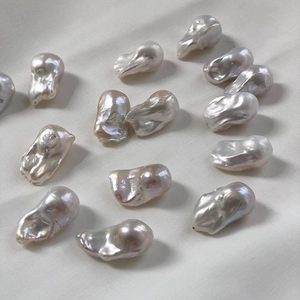 Natural irregular Baroque freshwater pearls scattered on white fabric background