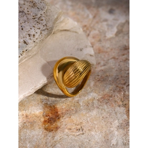 Macro view of golden waterdrop ring with ribbed texture and smooth finish on stone