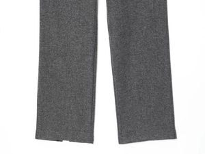 Gros plan du pantalon gris foncé texturé montrant les détails précis des ourlets cousus