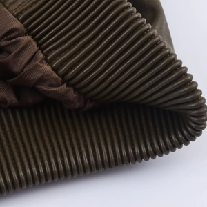 Détail de la texture en similicuir vert olive avec motifs côtelés et doublure de la veste