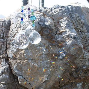 Detail of crystal prisms casting rainbow light spots on stone in natural sunlight