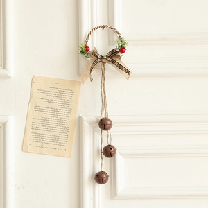 Vintage Christmas wall hanging with brown metal bells and red berries on a bow