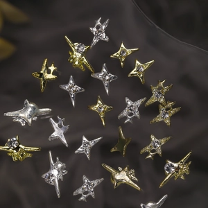 Macro shot of 3D star nail charms in gold and silver with sparkling rhinestones