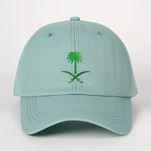 Close-up of embroidered green palm tree and crossed swords on a light blue cotton cap