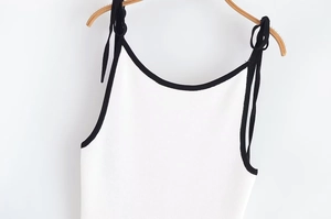 Détail du haut licou en tricot blanc avec bordure contrastée noire et bretelles réglables