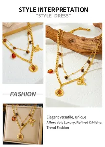 Close-up of double-layered gold necklace with tiger eye beads and sun pendant detail