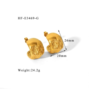 Détail de créoles dorées épaisses avec finition martelée, dimensions 26mm par 20mm