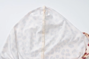 Close-up of overlock stitching and fabric texture on leopard print hooded set