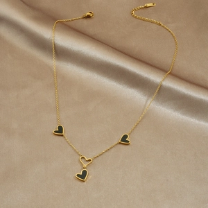 Elegante collana in acciaio dorato con pendenti a cuore neri su raso color champagne