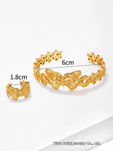 Detail of gold butterfly filigree jewelry set with open ring and adjustable bangle
